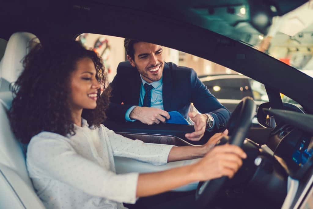 mixed race woman enjoying new car